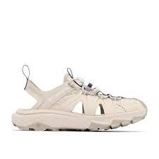 Sort sandal med beskyttende tå og hurtigsnor lukning.